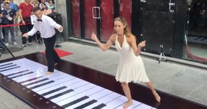 couple plays the pink panther theme on big piano